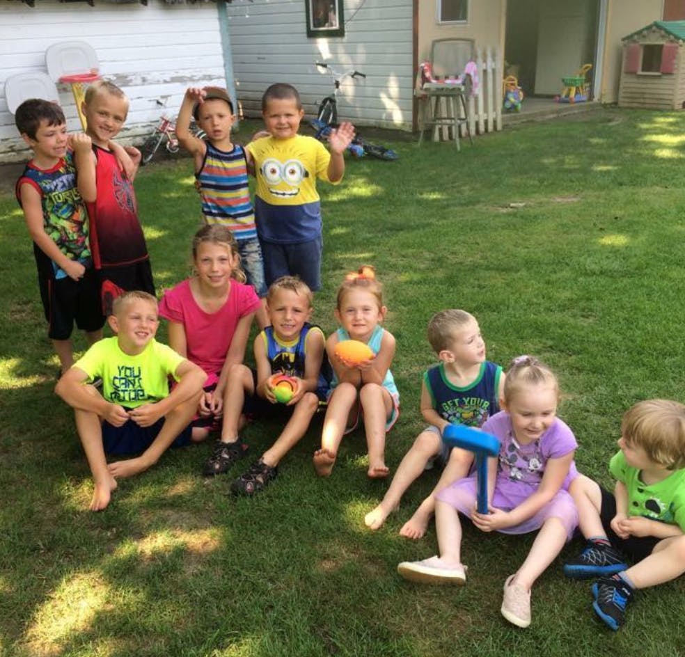 Group of children sitting and standing on grass