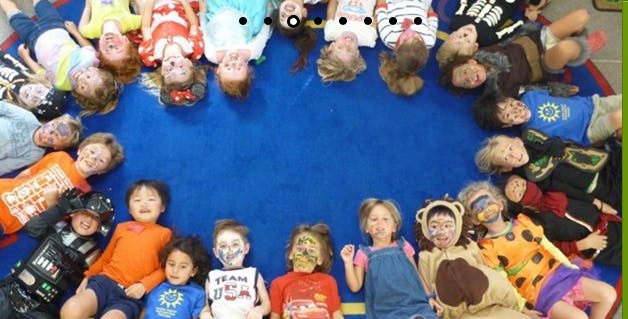 Children lying in a circle on a blue mat