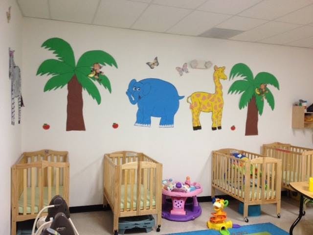Nursery room with cribs and animal wall decals