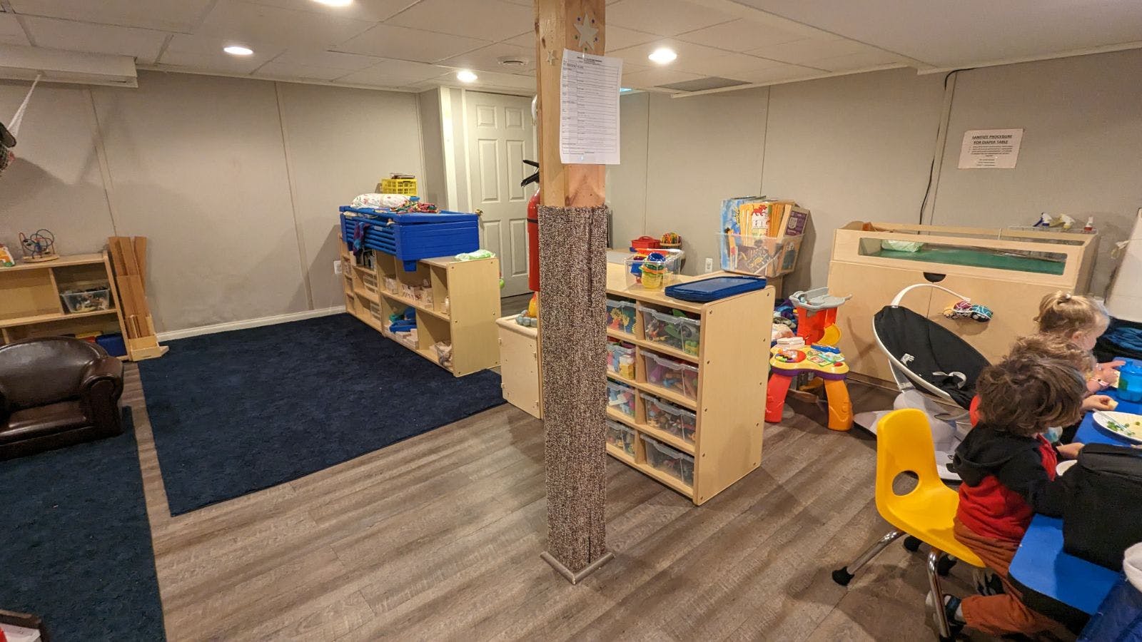 Children in a playroom with toys and furniture