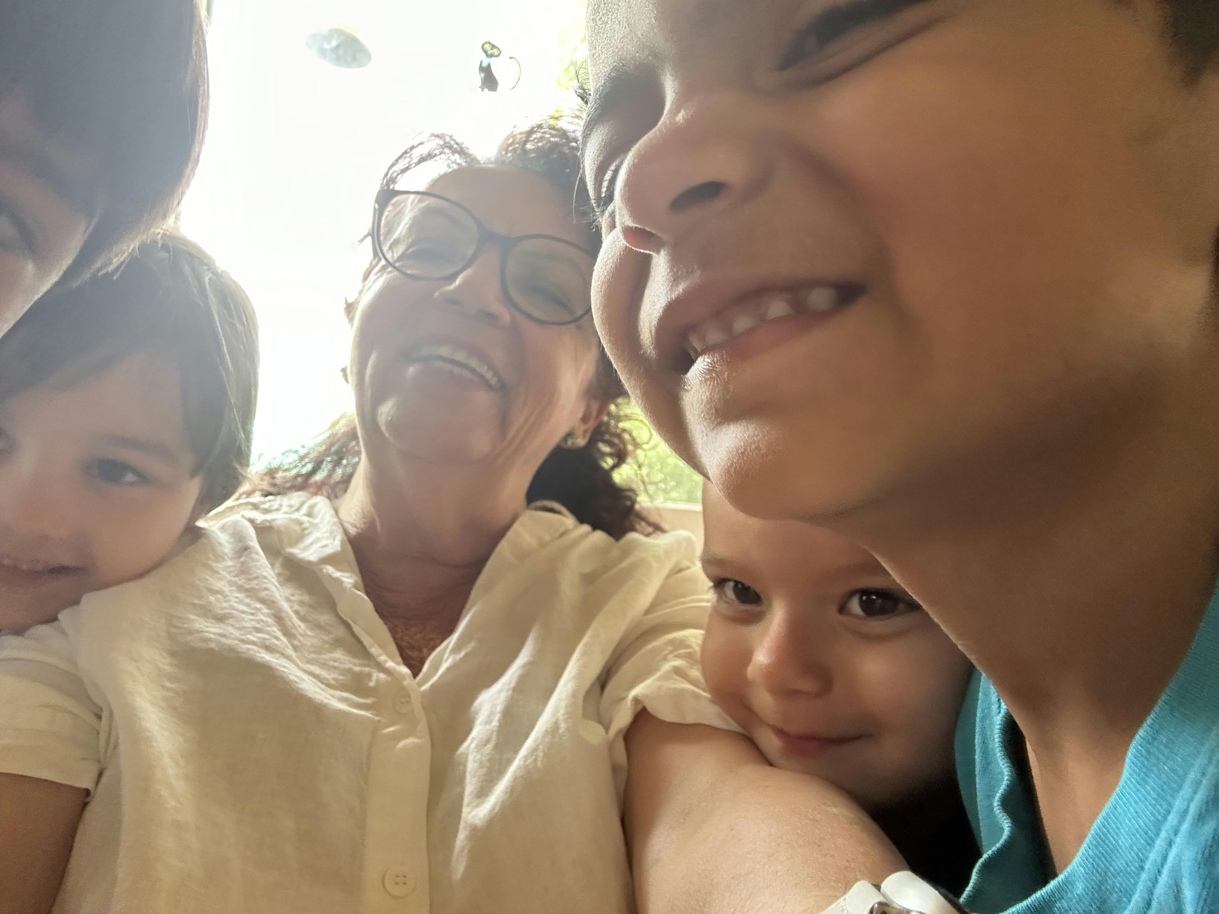 Person with glasses and three children looking at camera