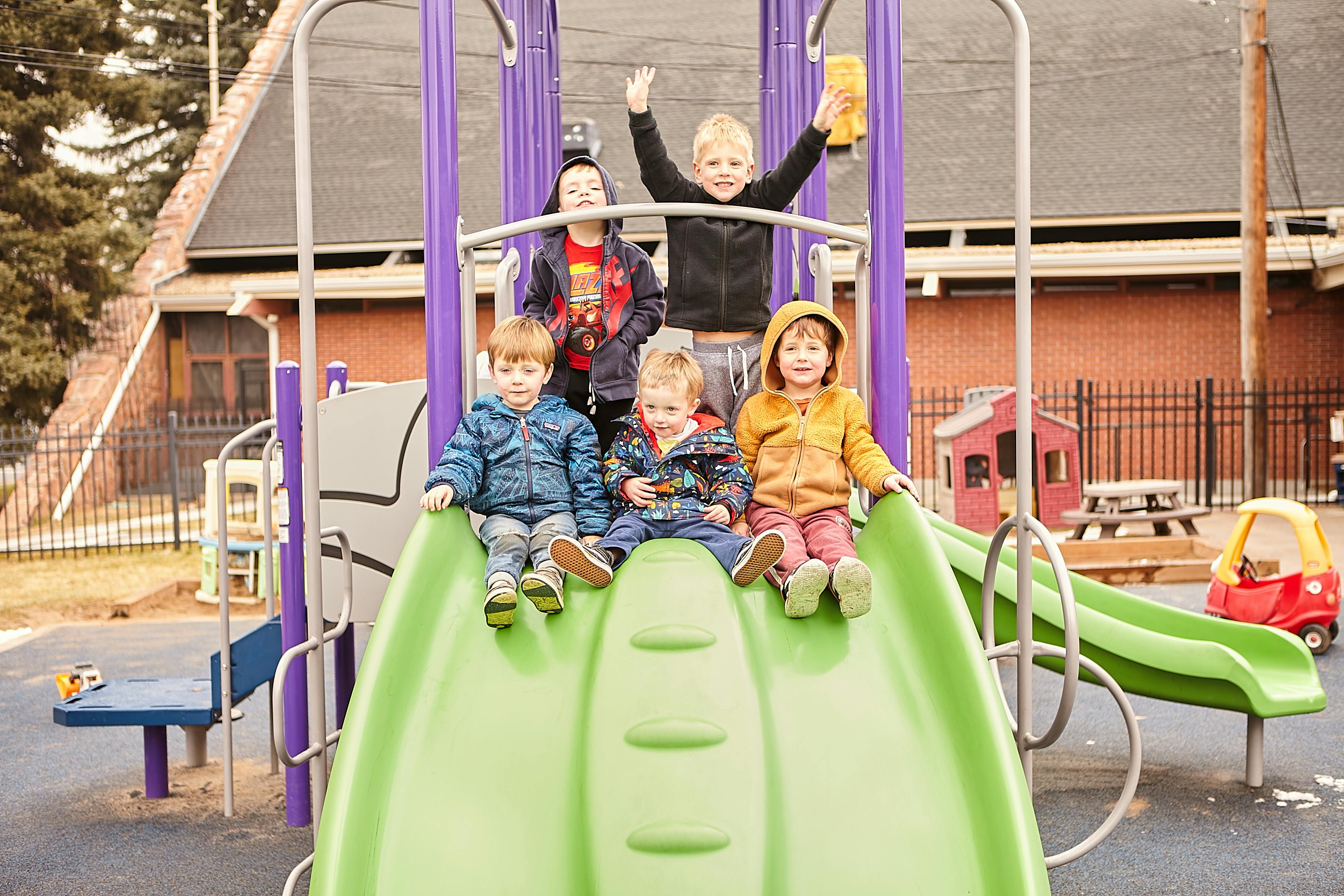 Children on a playground slide and climbing structure