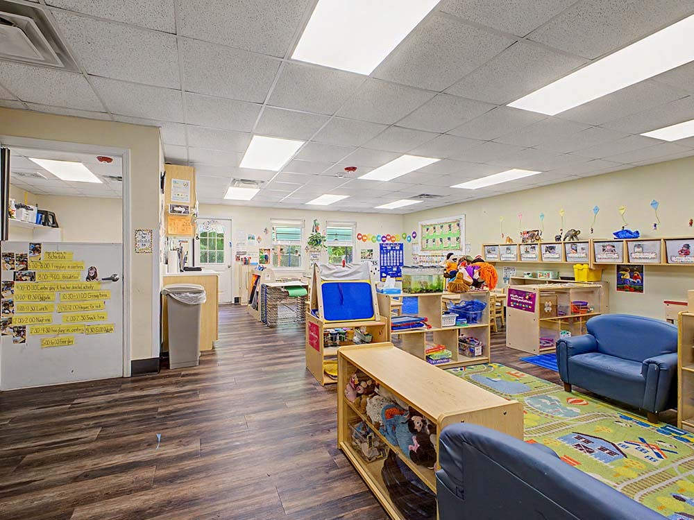 Empty colorful preschool classroom with small furniture and toys