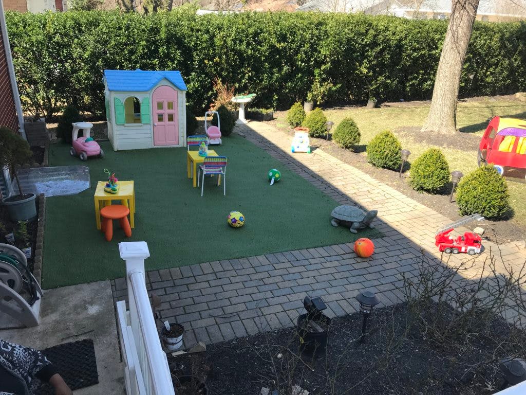 Playhouse and toys on artificial turf in a backyard