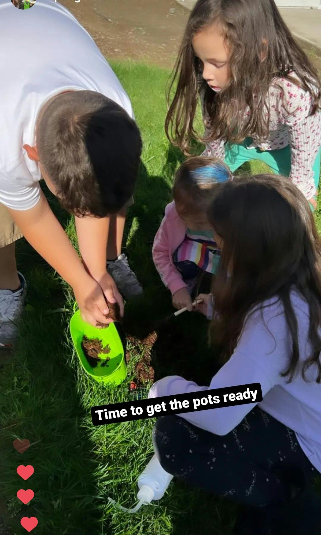 Person and children planting in the grass