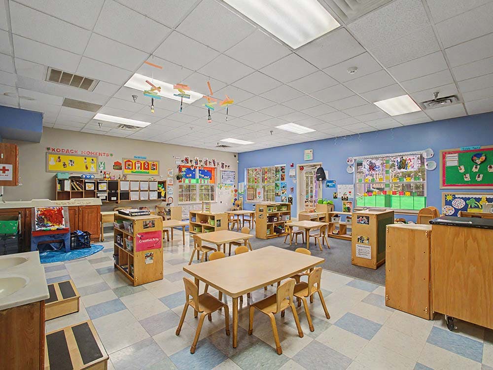 Empty colorful children's classroom with small tables and chairs