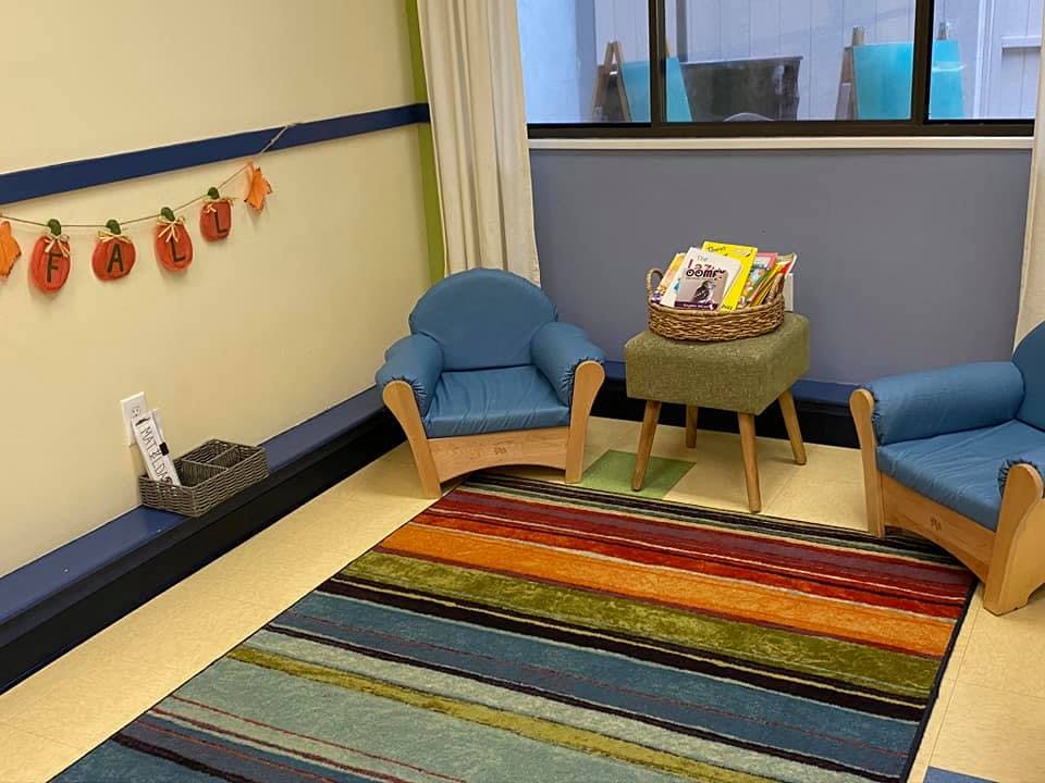 Children's chairs and a colorful rug in a room