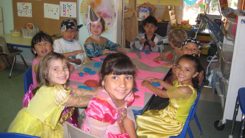 Children in costumes sitting around a table