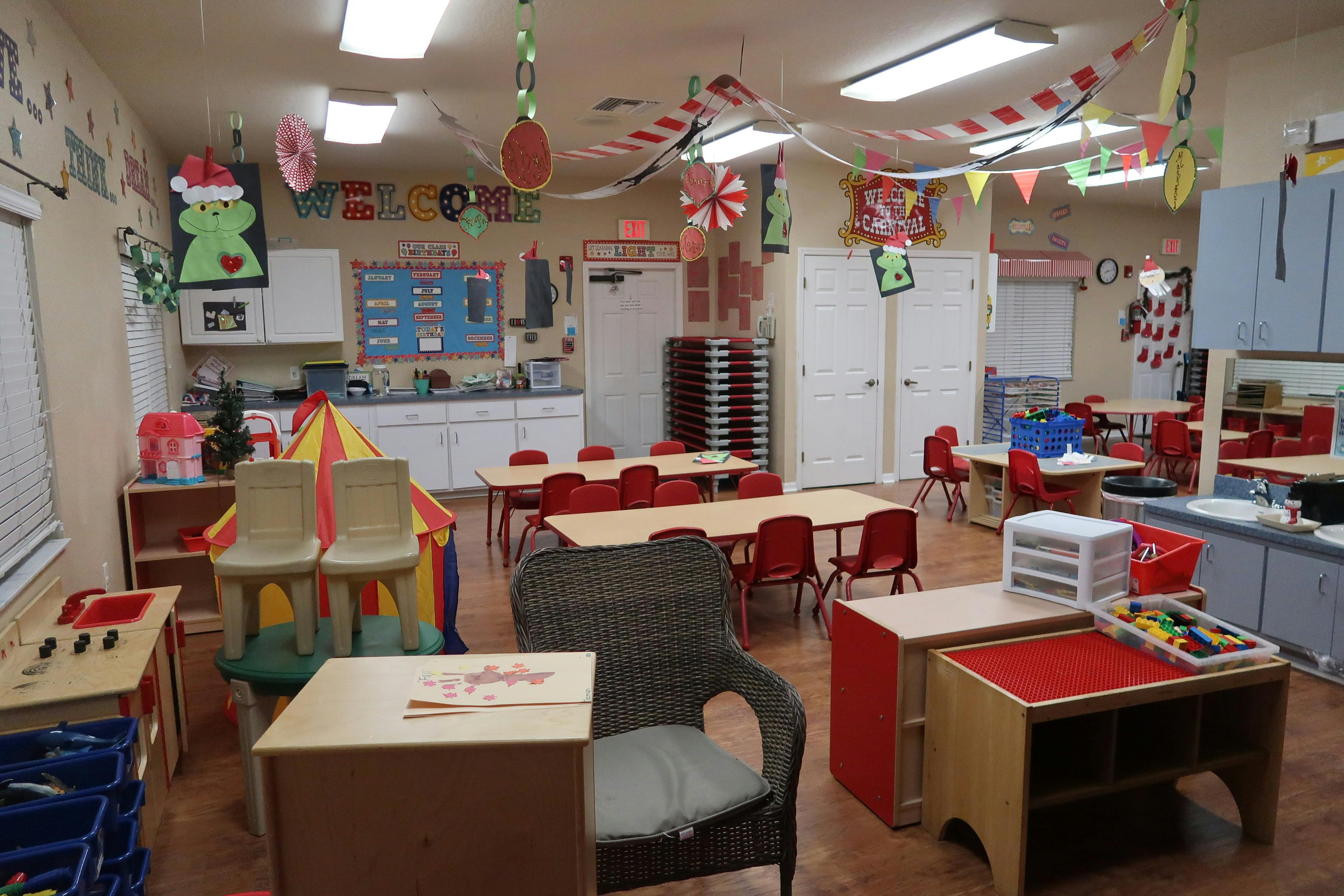 Classroom with small tables and chairs, decorated with festive banners and cutouts