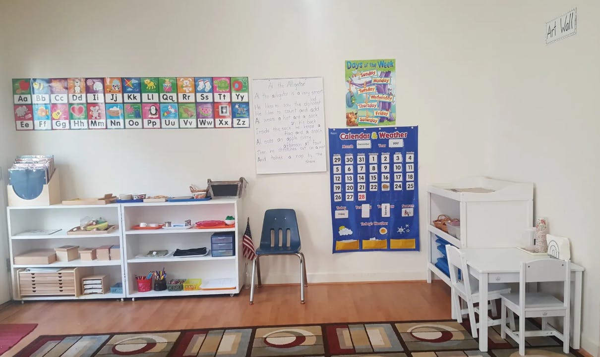 Classroom with shelves, small tables and chairs, and educational posters