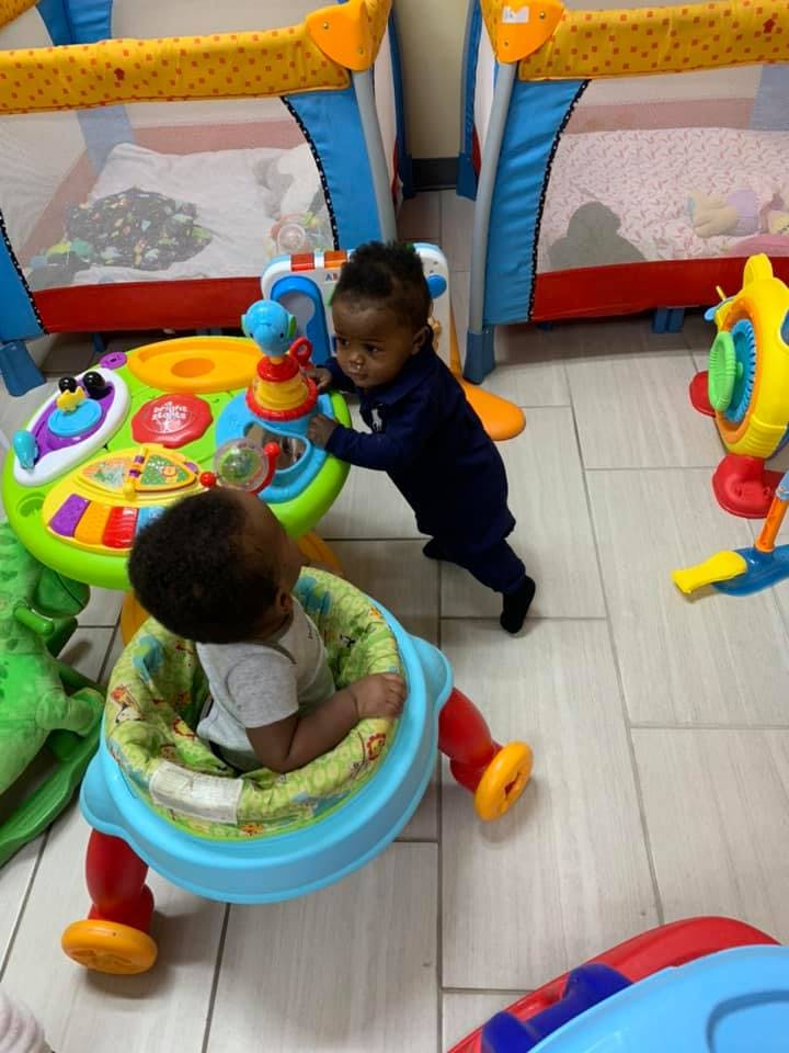 Two children playing with colorful toys on the floor