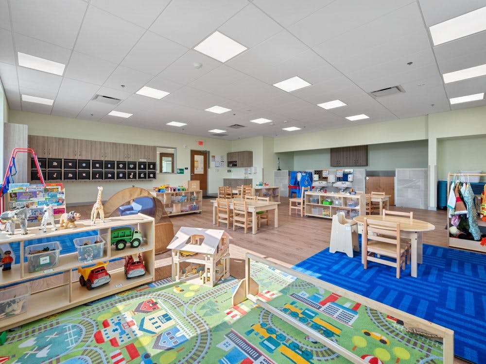 Classroom with children's toys, tables, and a colorful rug with a road design