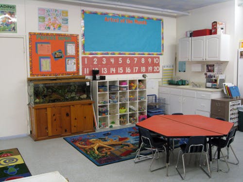 Classroom with a fish tank, storage cubbies, and a hexagonal table