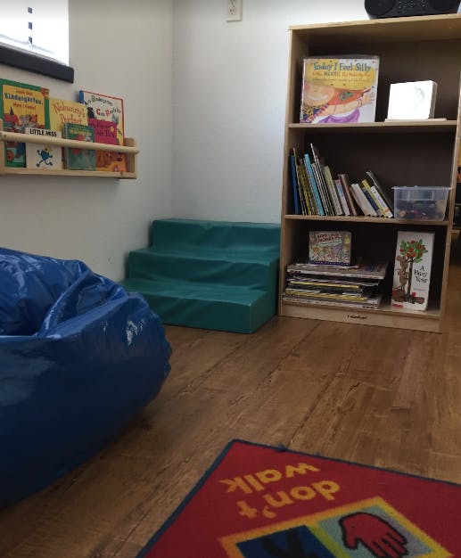 Children's reading nook with beanbag, steps, and bookshelves