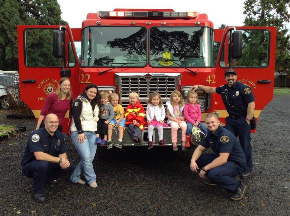 People and children posing in front of a fire truck