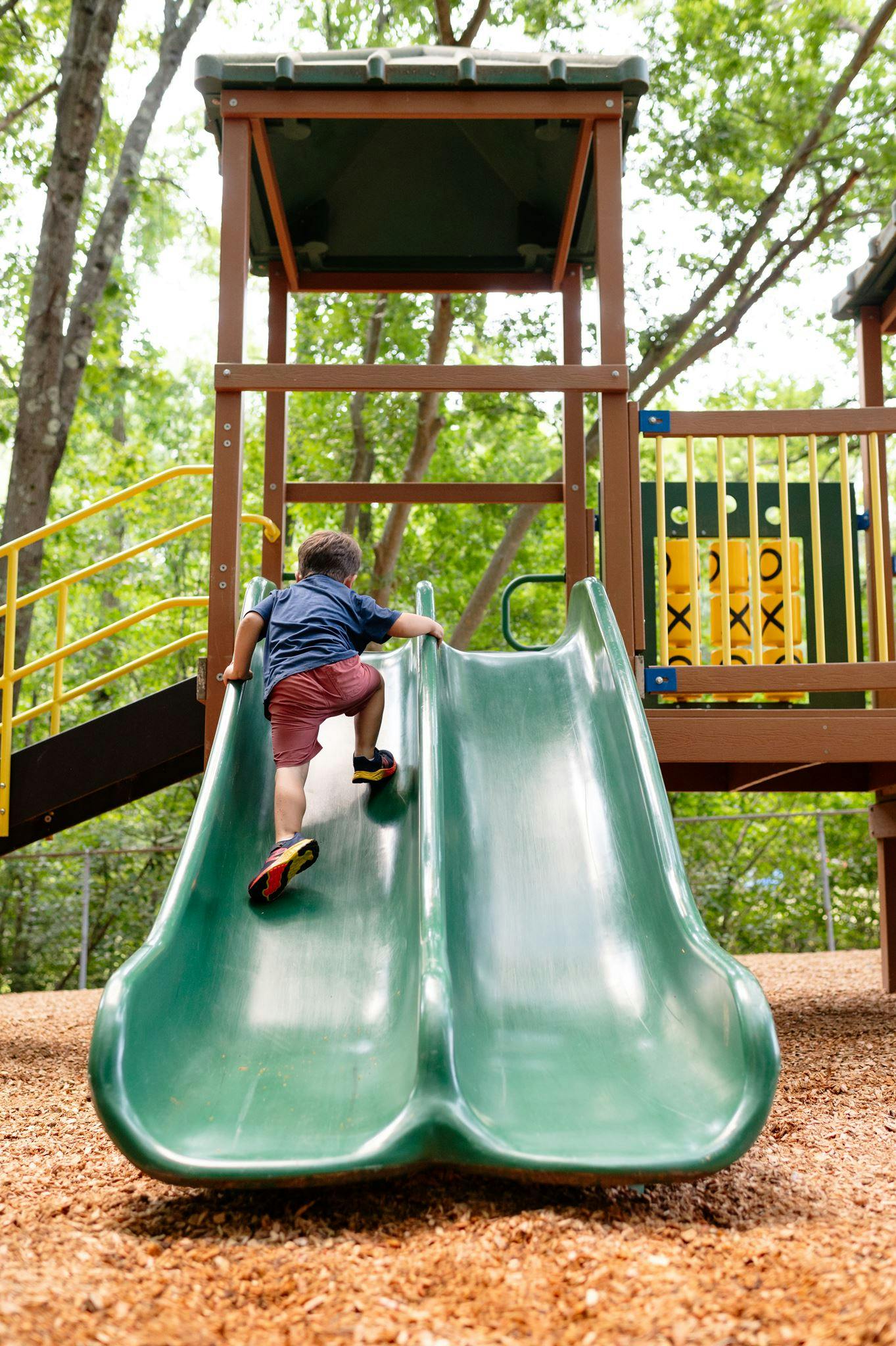 Child climbing up a playground slide