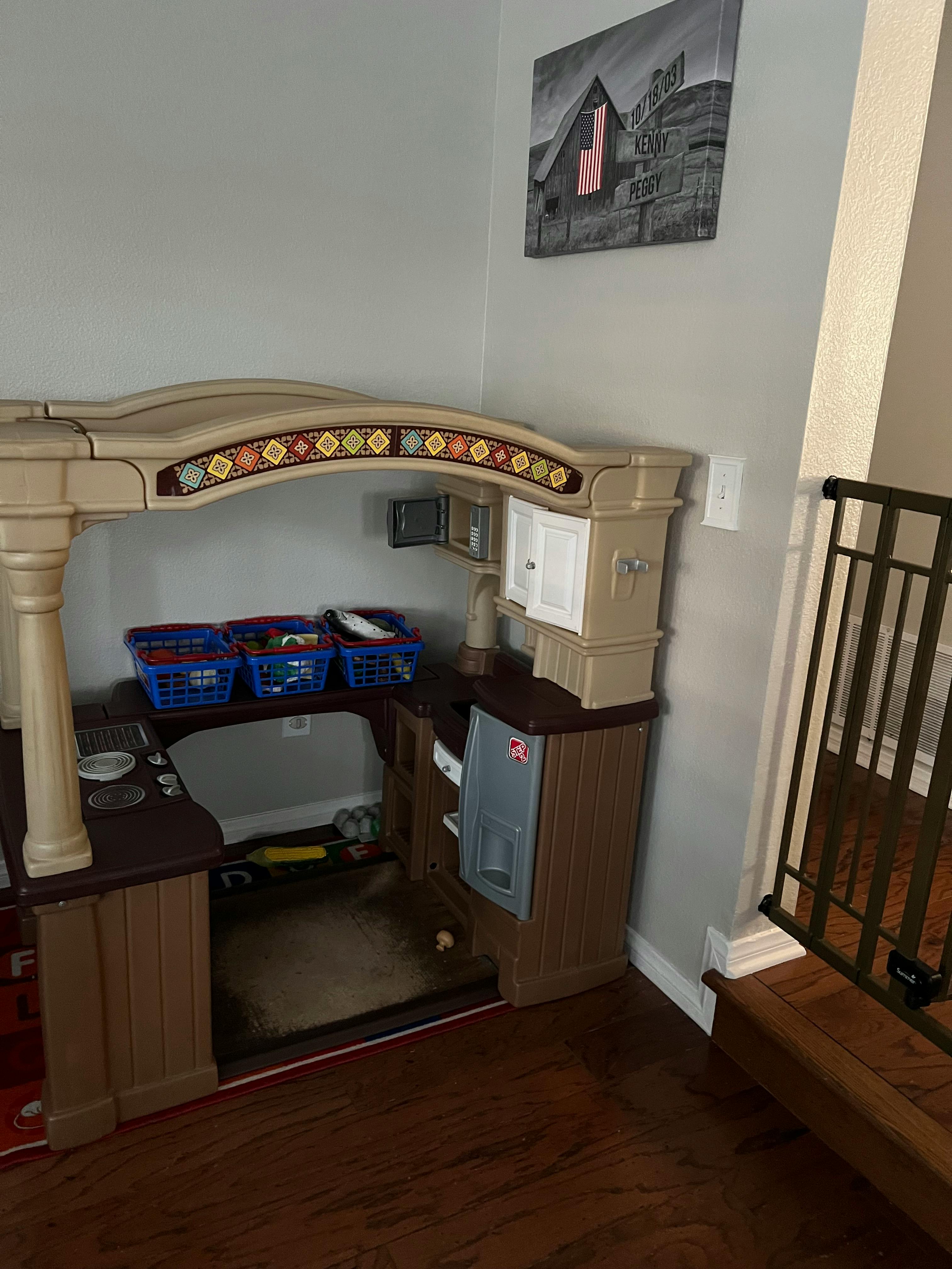Child's play kitchen with blue baskets and a gate