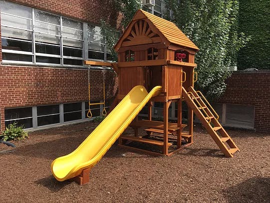 Wooden playground set with a yellow slide and ladder