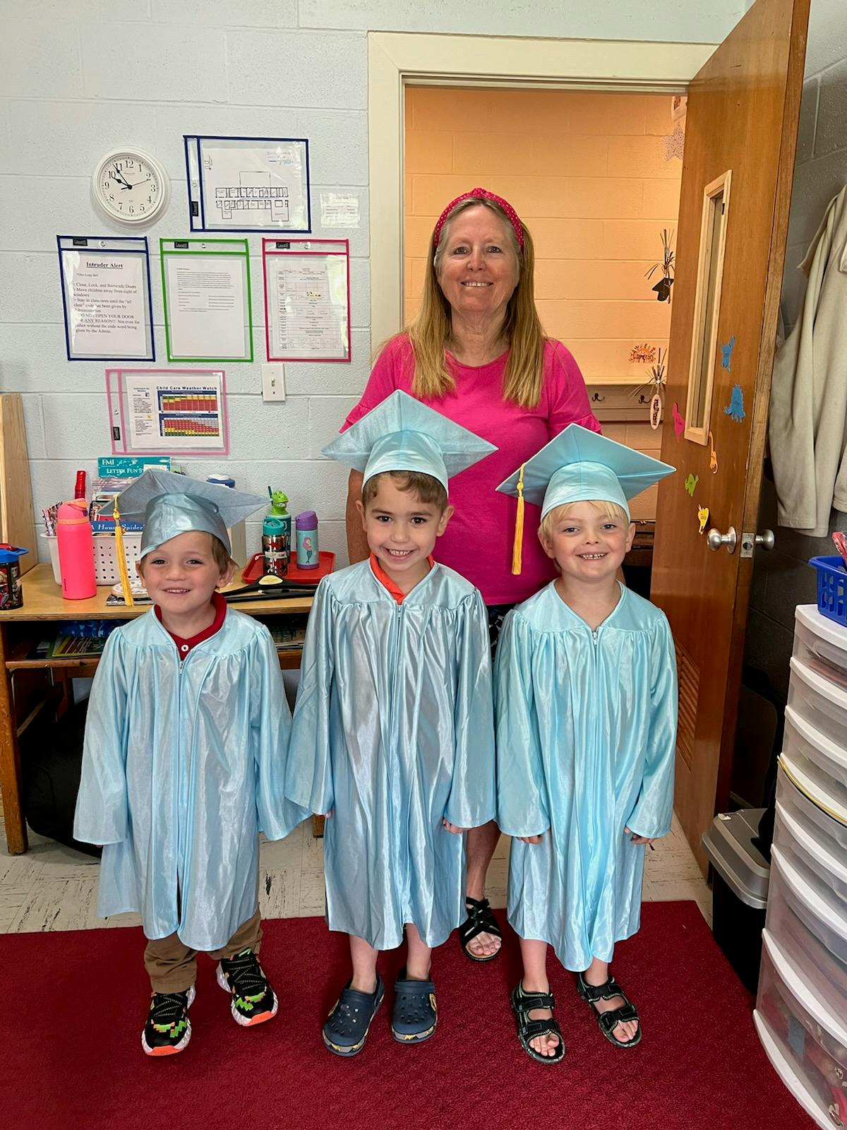Adult and three children in graduation caps and gowns