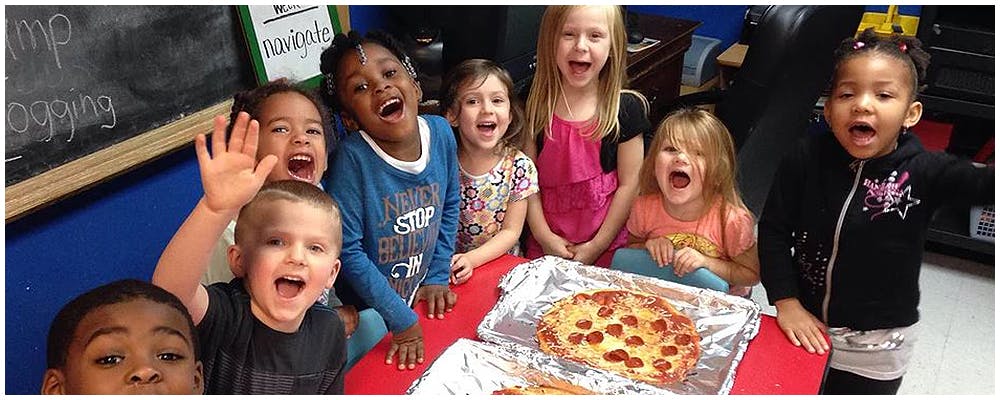 Group of children with open mouths around a pizza