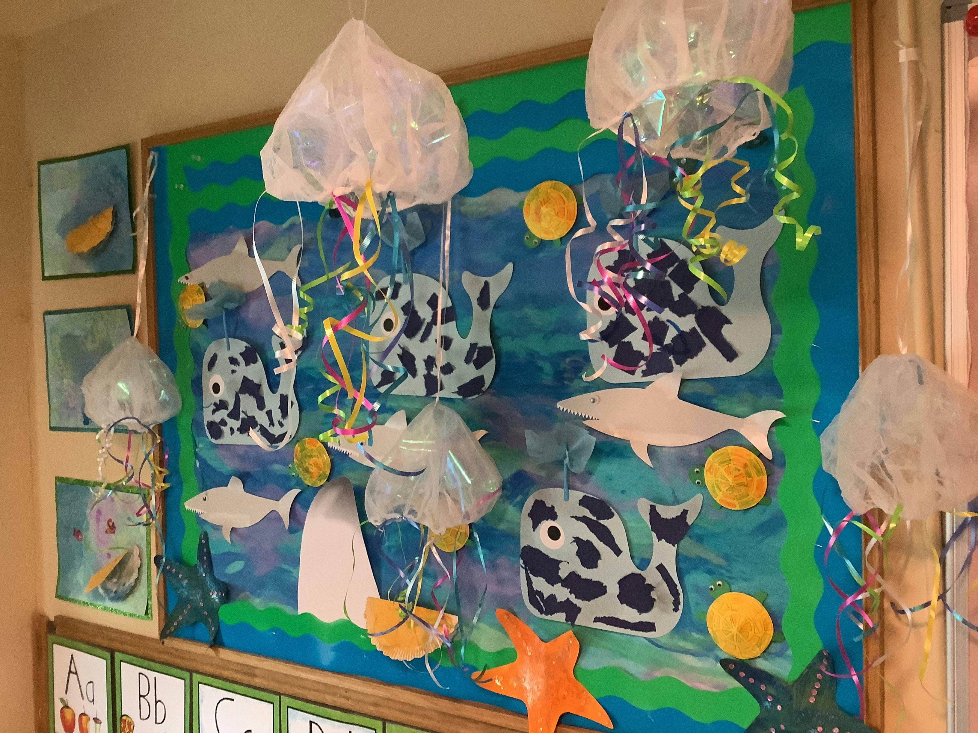 Ocean-themed bulletin board with paper fish, sharks, and jellyfish decorations