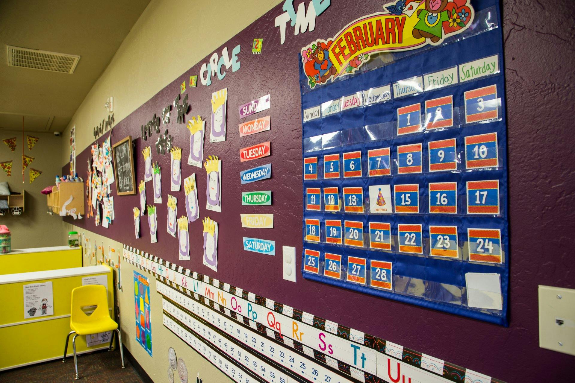 Classroom wall with a February calendar and children's artwork