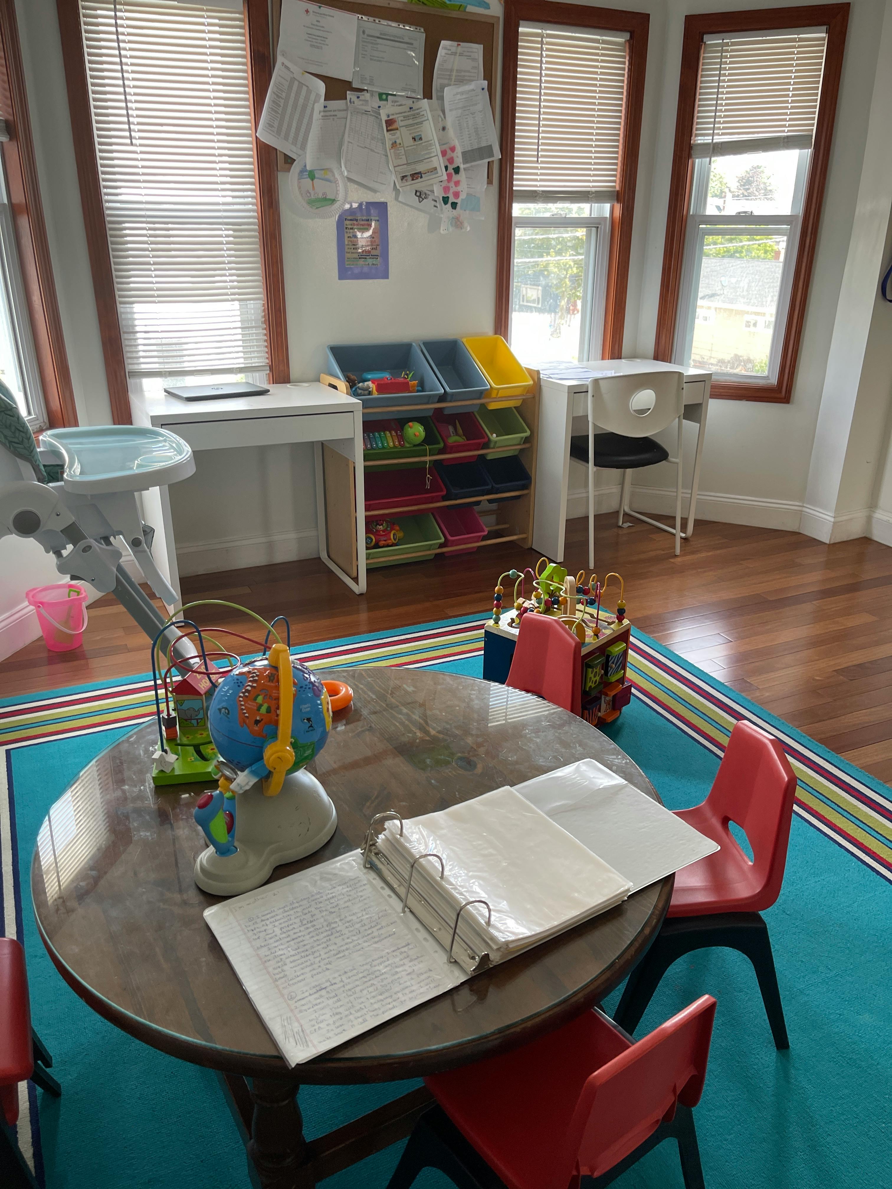 Playroom with a round table, chairs, toys, and storage bins