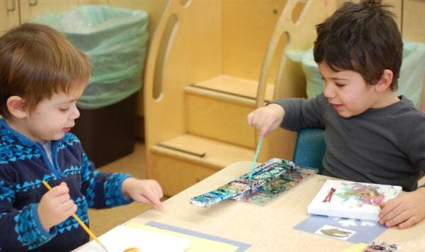 Two children at a table doing an activity
