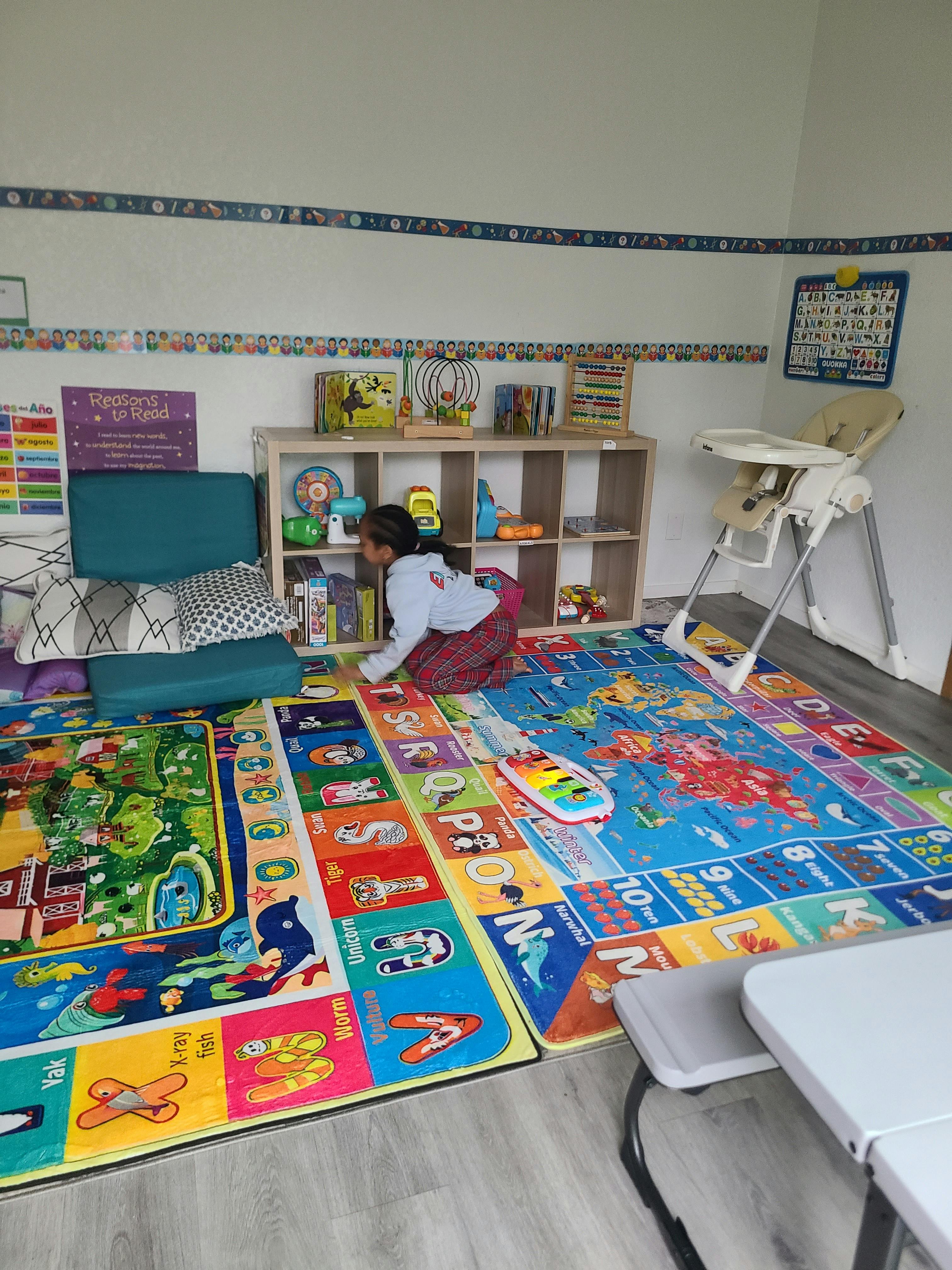 child looking at books on a bookshelf in a playroom