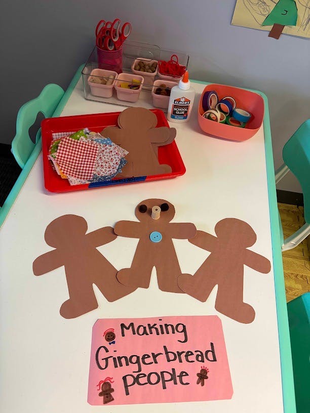Gingerbread man paper cutouts and craft supplies on a table
