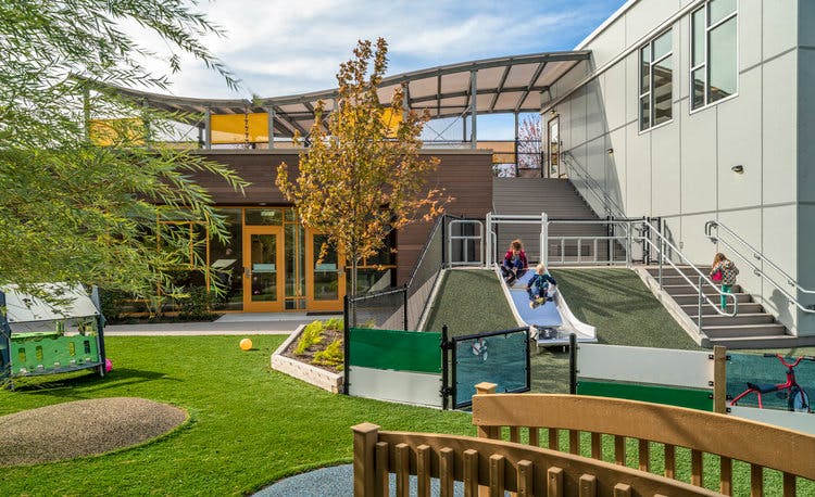 Children playing on a slide and stairs at a modern building