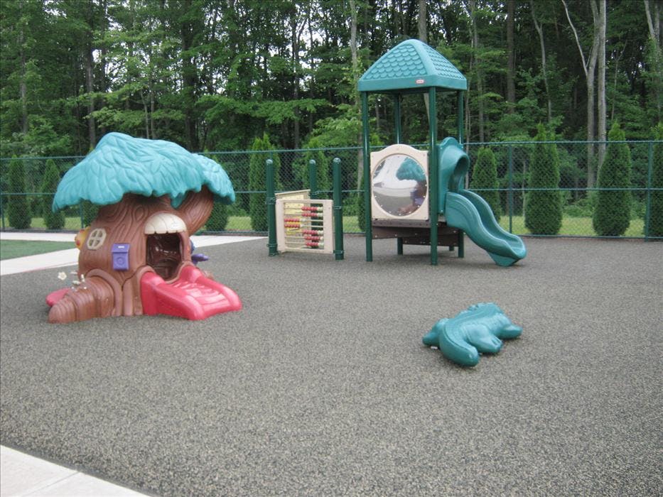 Playground with treehouse slide, abacus, and covered slide structure on soft ground