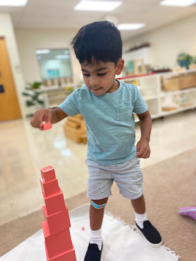Child stacking blocks in a classroom
