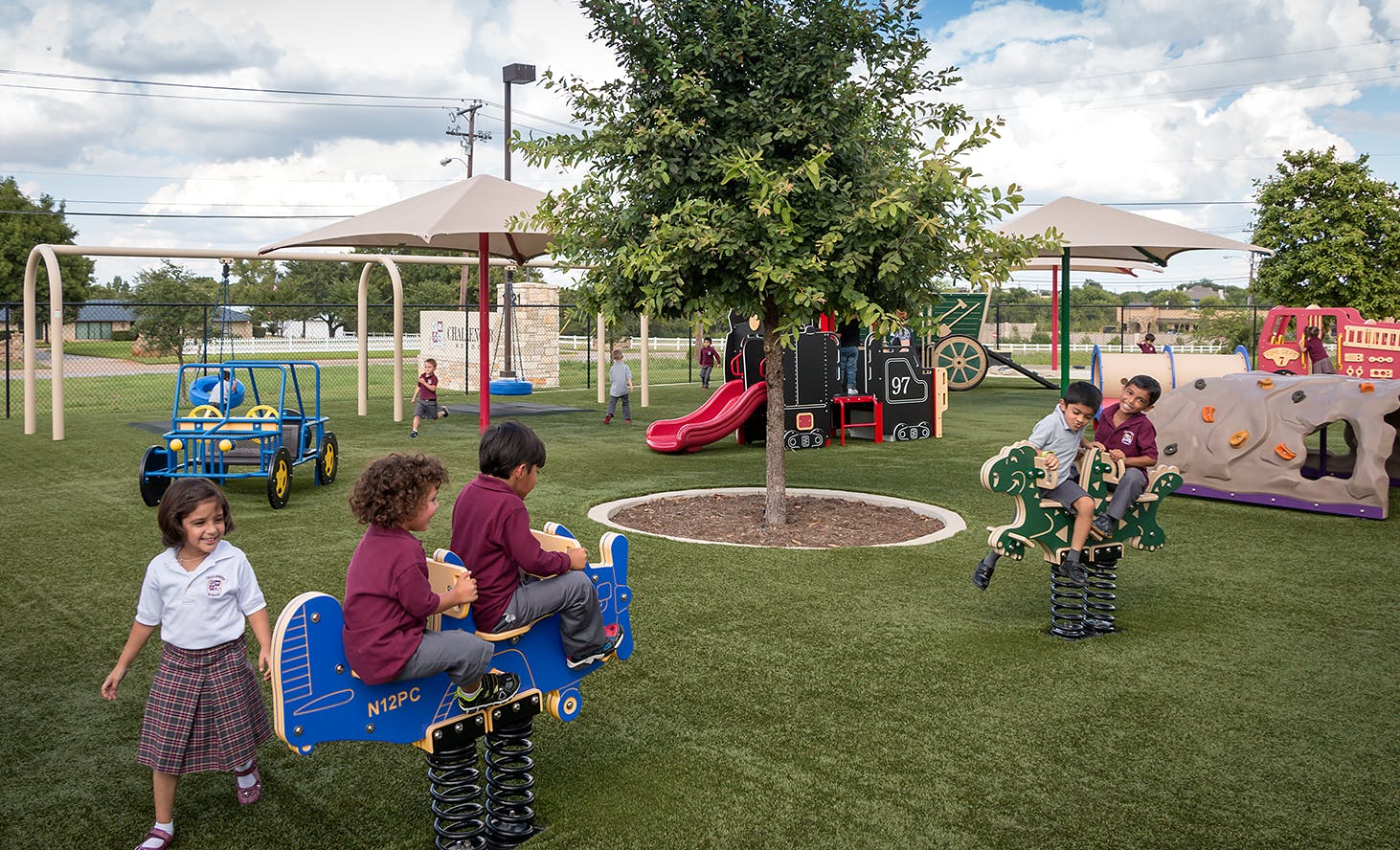 Children playing on spring riders and other equipment on a playground