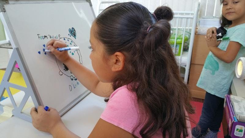 Child drawing on a whiteboard