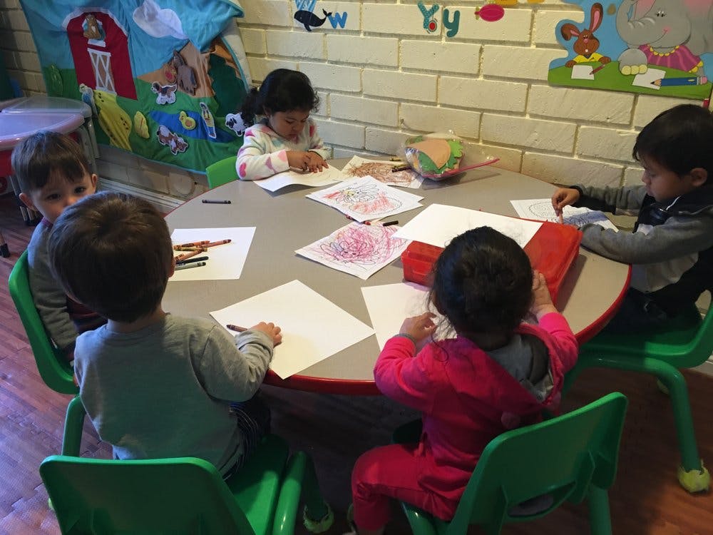 Children drawing at a table in a classroom