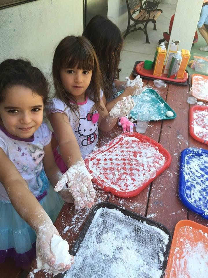 Two children playing with flour on a table