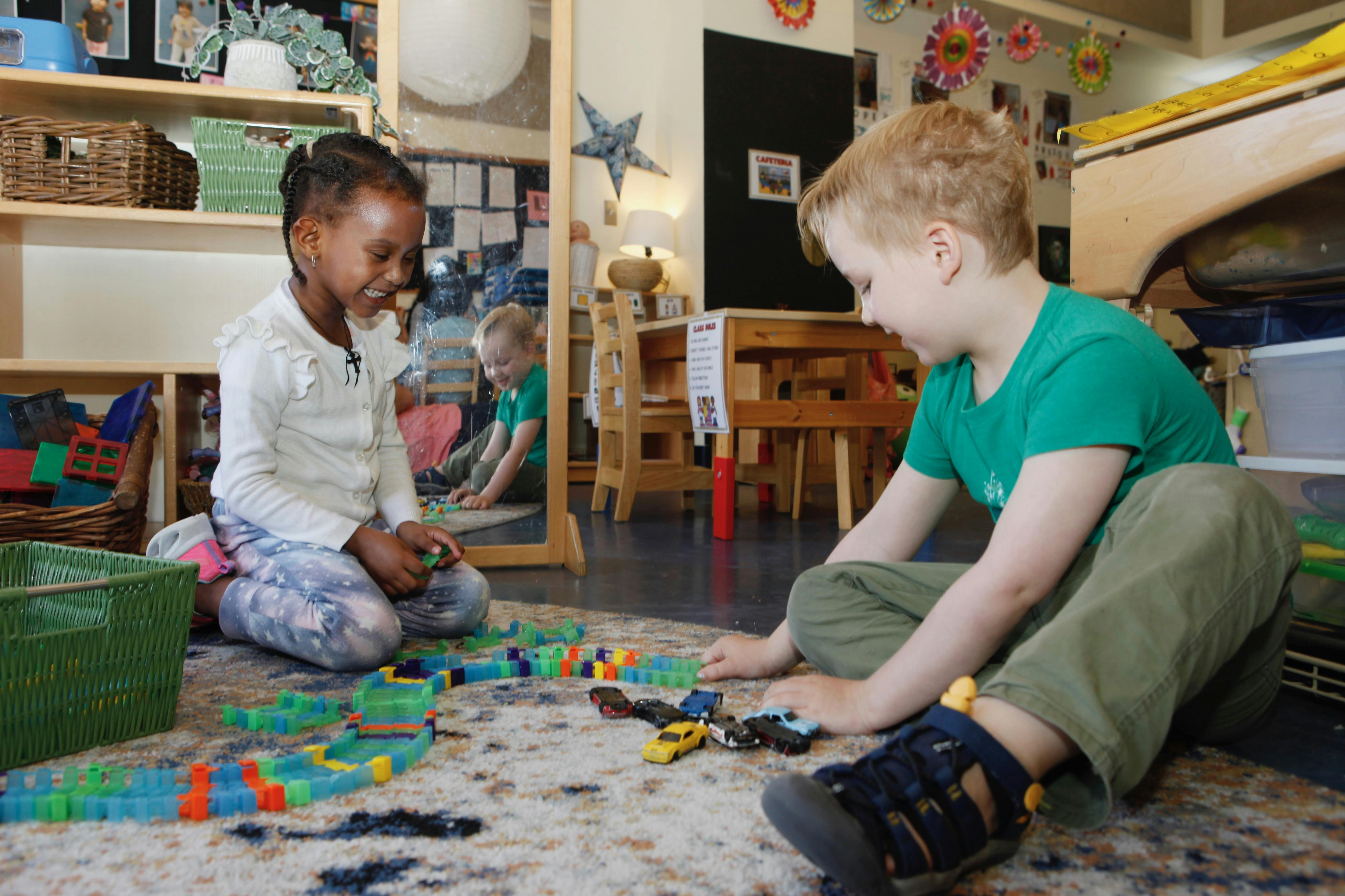 Two children playing with toys on a rug