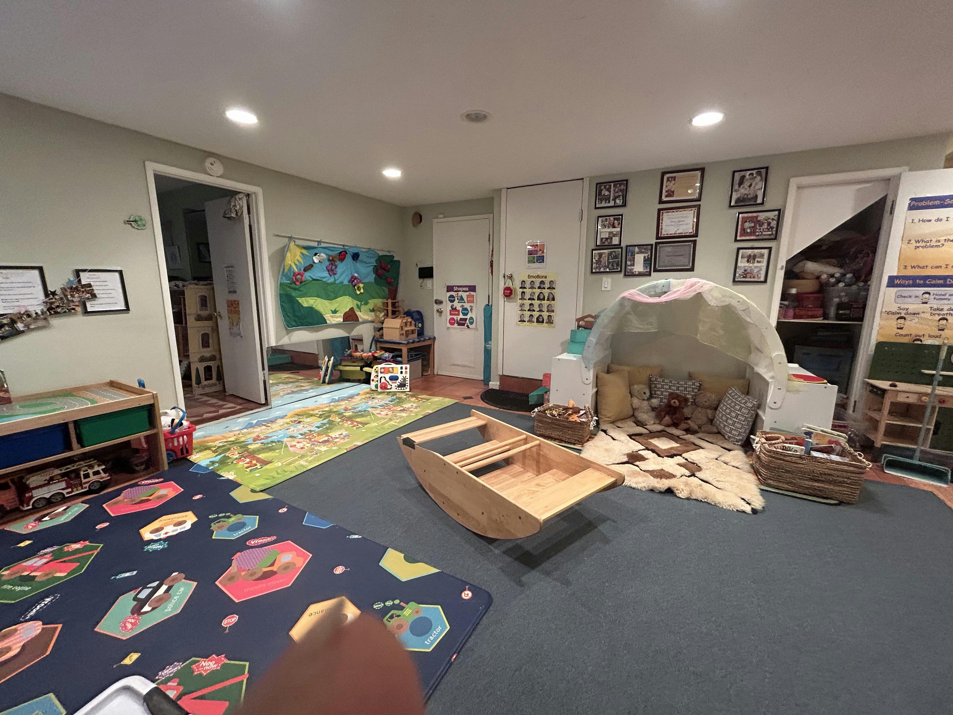Playroom with various educational toys, play mats, and a small tent