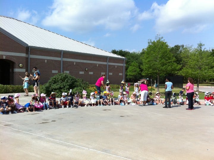 Adults and children sitting in a circle outdoors