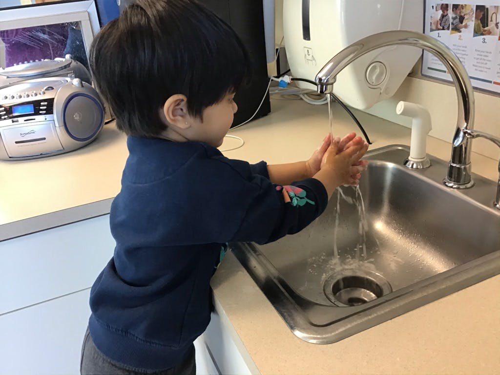 Child washing hands in a sink