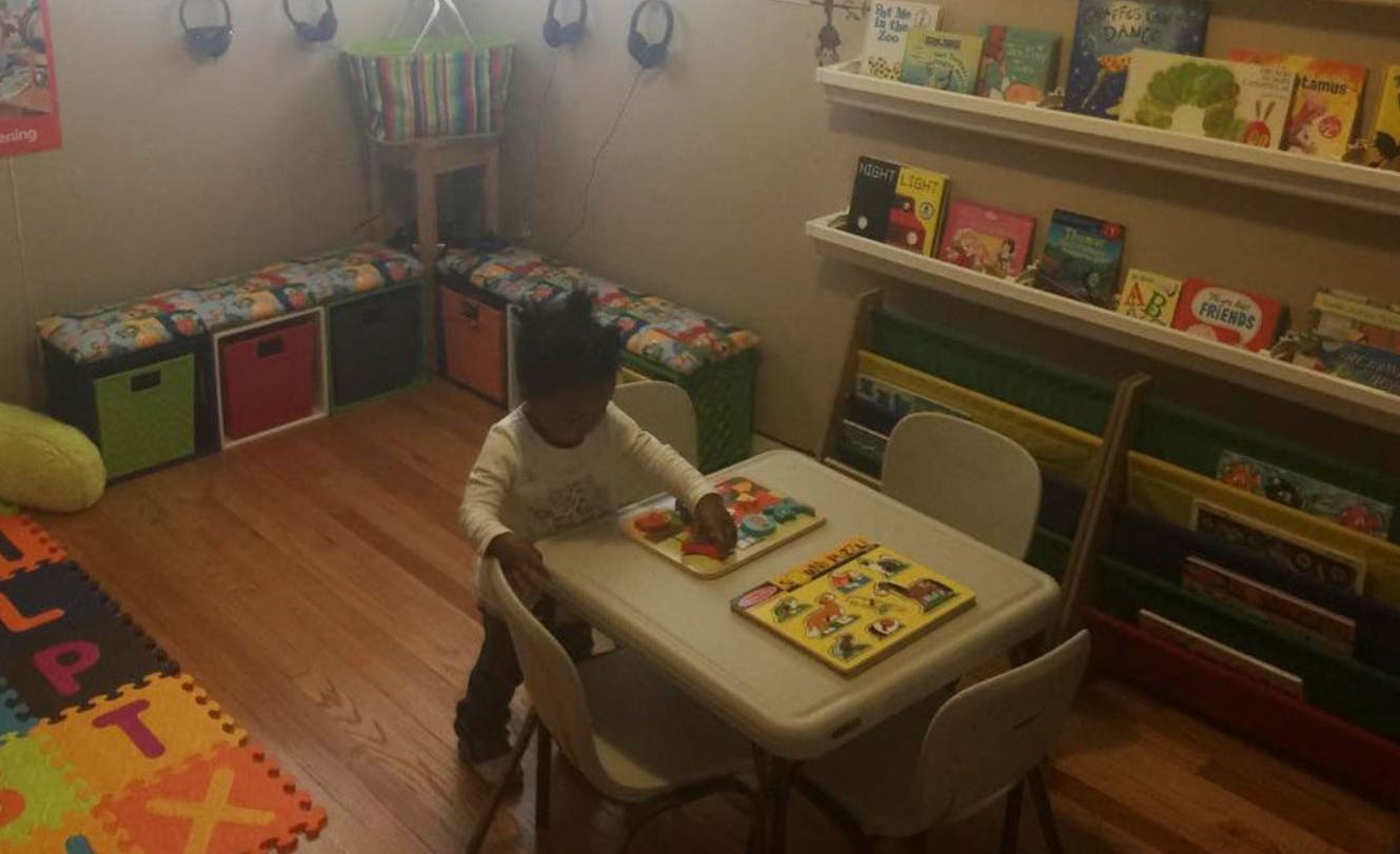 Child playing with puzzles at a small table in a room
