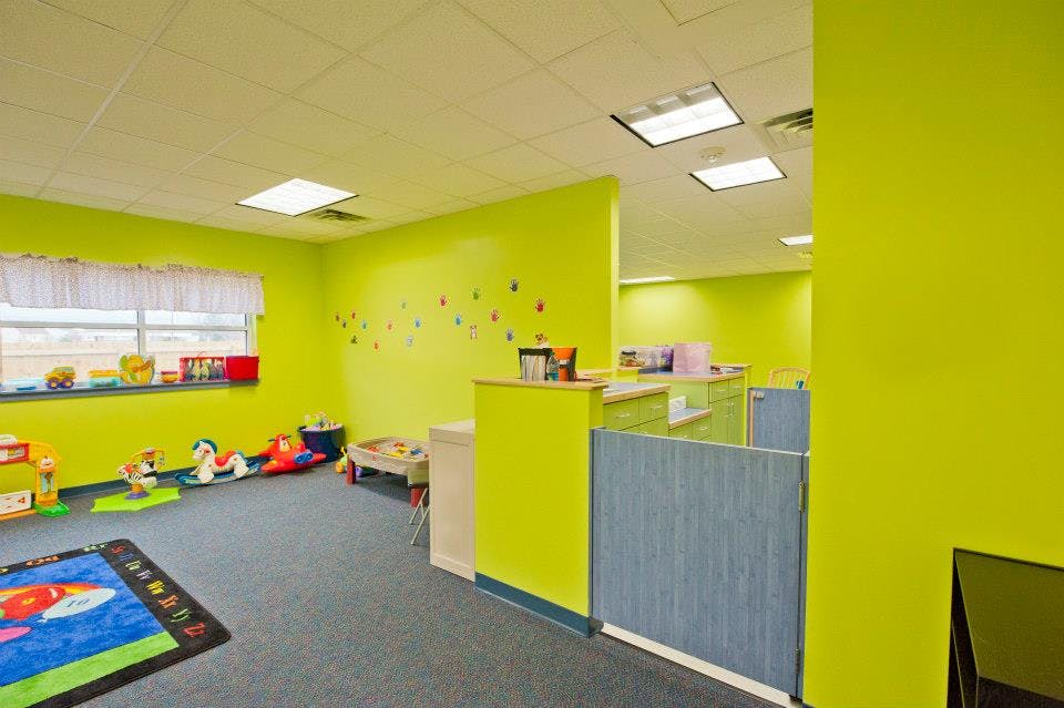 Playroom with bright green walls and colorful toys on the floor