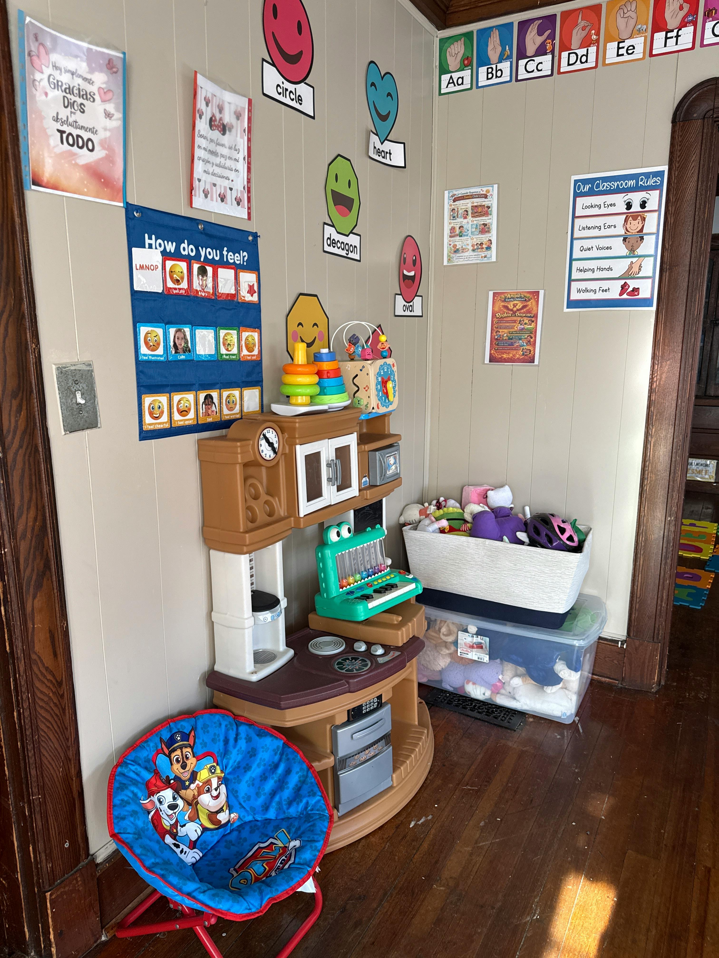 Play kitchen and folding chair in a room with educational wall posters