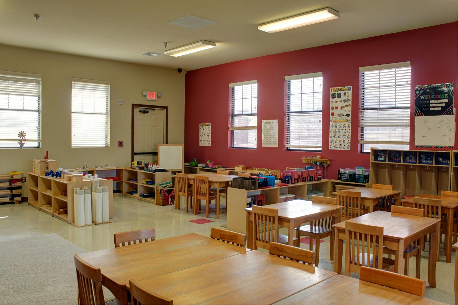 Empty classroom with small wooden tables and chairs