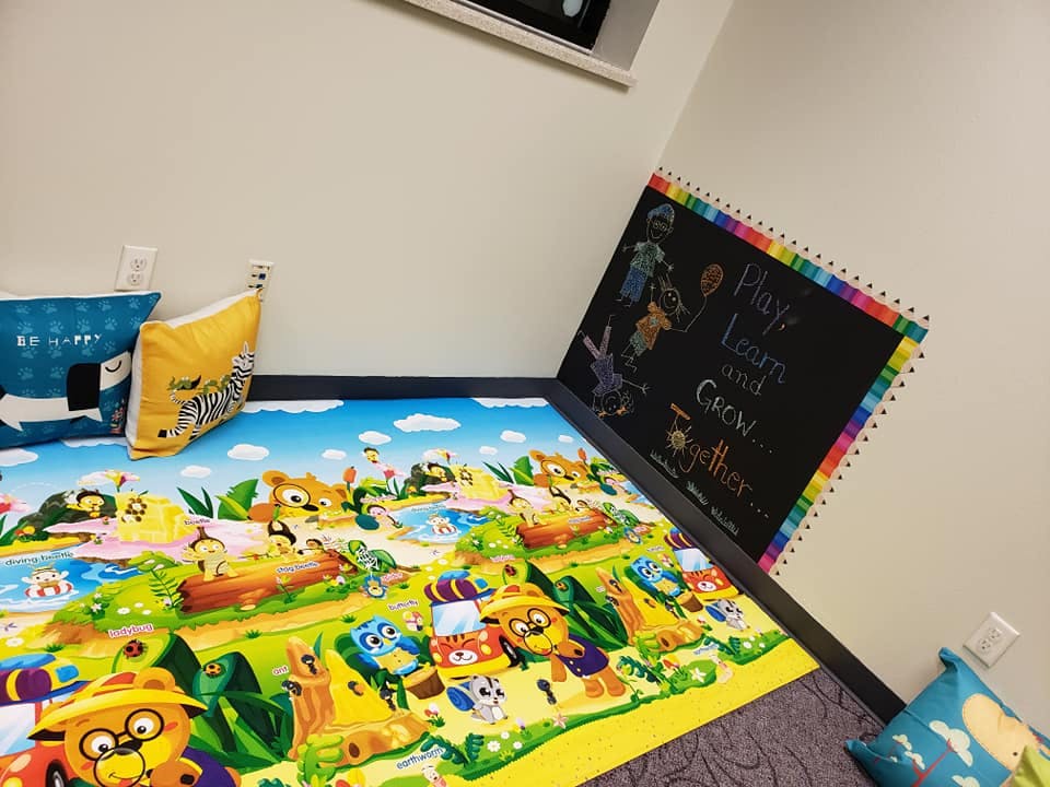 Playmat with cartoon animals and a chalkboard with "Play Learn and Grow Together"