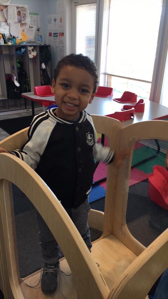 Child standing in a wooden play structure