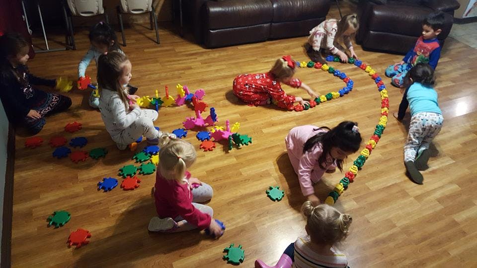 Children playing with colorful toys on a wooden floor