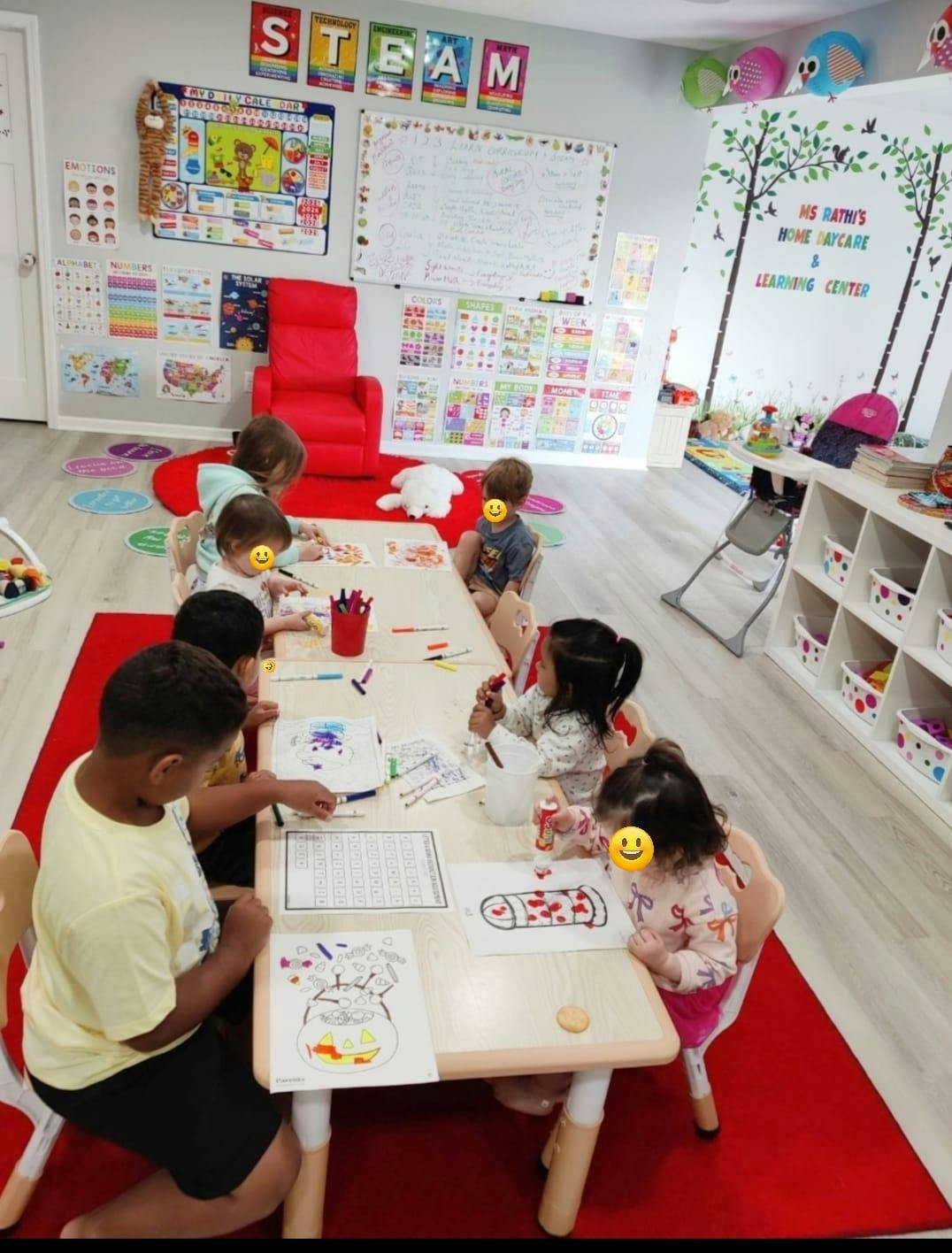 Group of children sitting at a table coloring in a classroom
