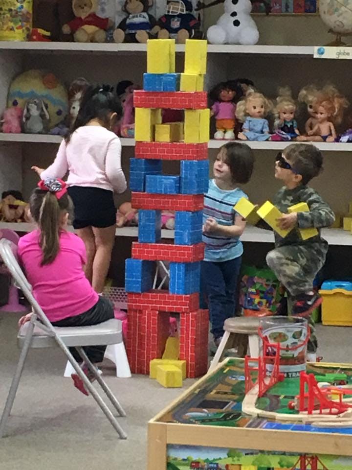 Children playing with large building blocks in a classroom